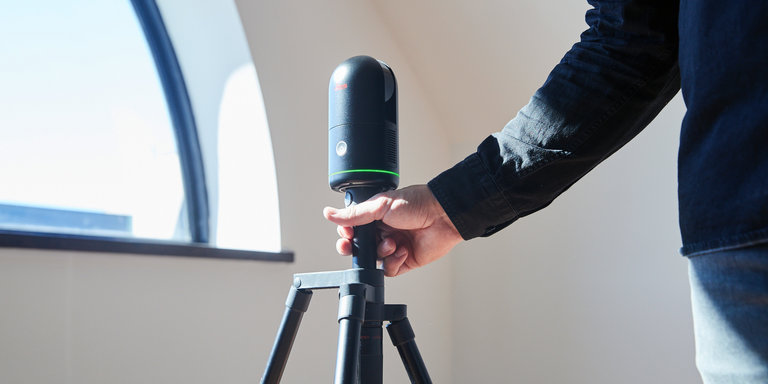 Person holding a BLK360 on a tripod