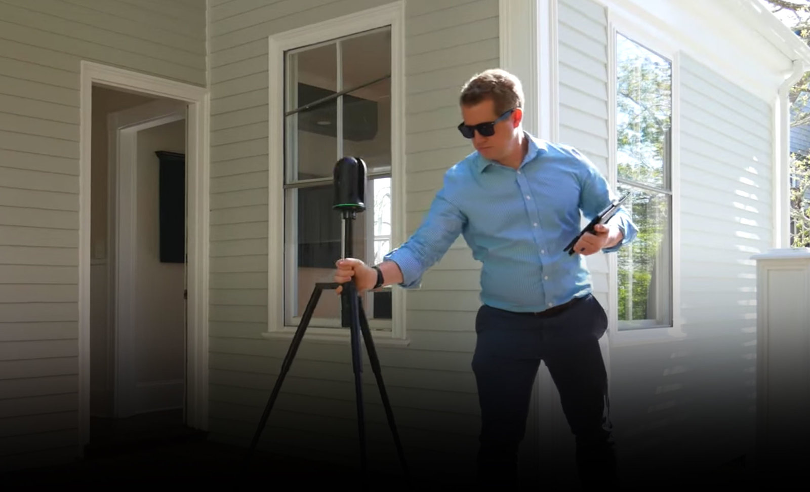 un hombre usa el BLK360 para escanear una casa